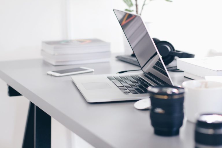 laptop and cup of coffee on white table