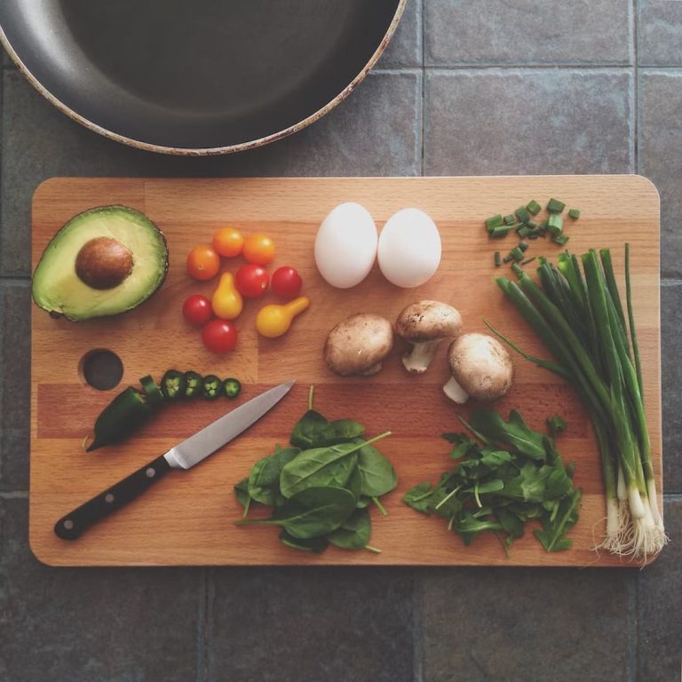 Eggs, vegetables and a knife on the cutting board
