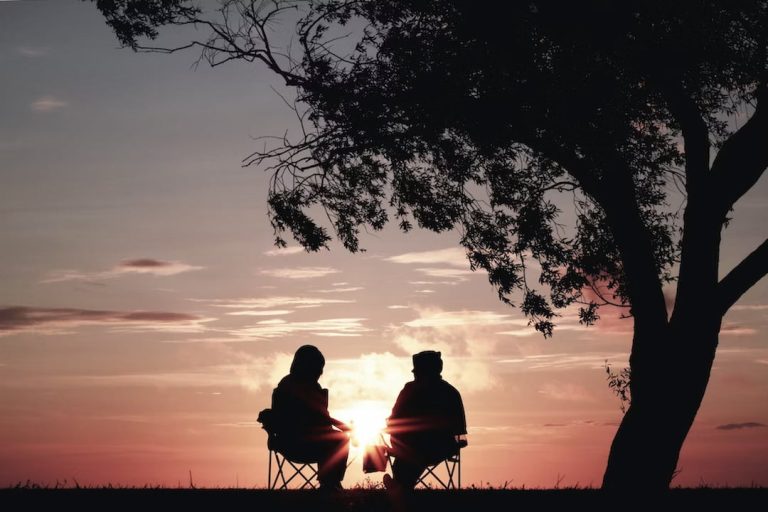 Two people under the tree in sunset